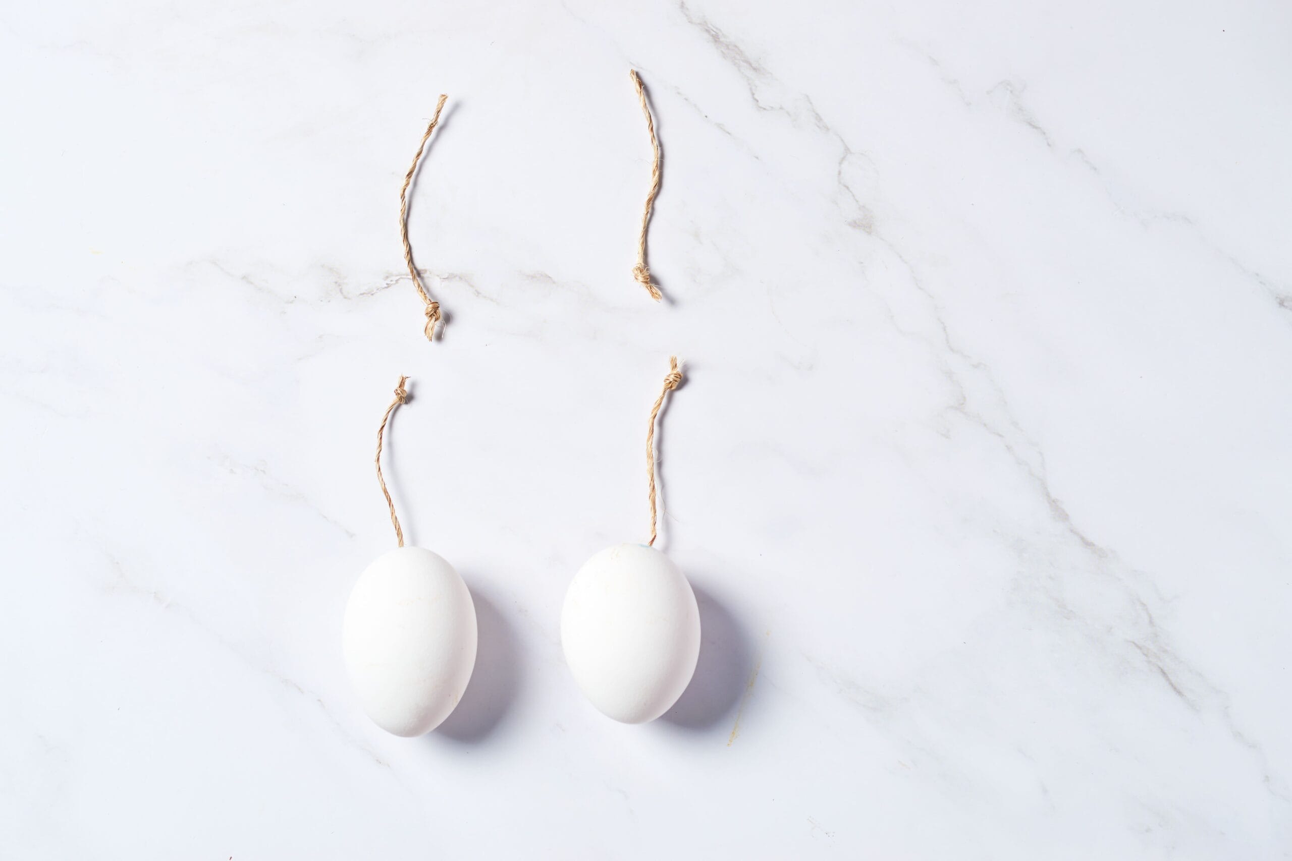Huevos de gallina con cuerdas simulando testículos