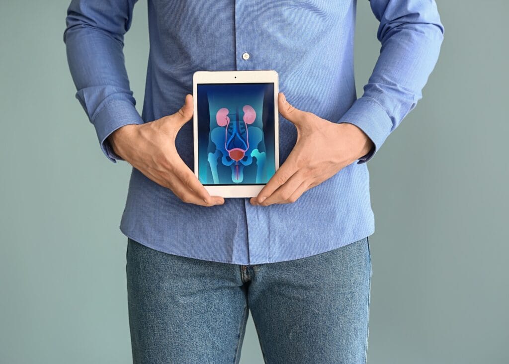 Hombre sosteniendo tablet con imagen de sistema urinario